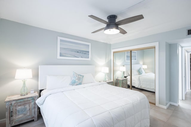 tiled bedroom with ceiling fan and a closet