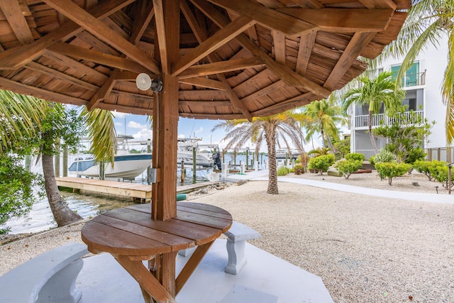 view of patio with a boat dock and a water view