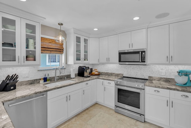 kitchen featuring stainless steel appliances, sink, pendant lighting, and white cabinets