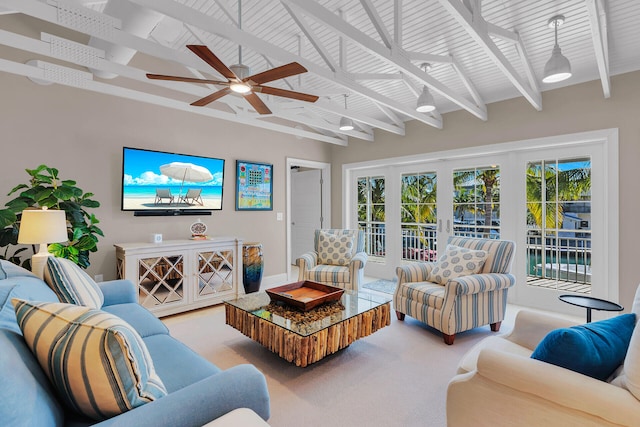 carpeted living room with ceiling fan, plenty of natural light, and beam ceiling