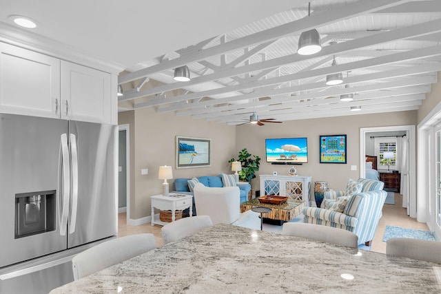 dining area featuring beamed ceiling and ceiling fan