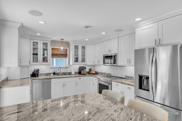 kitchen with sink, a breakfast bar, appliances with stainless steel finishes, hanging light fixtures, and white cabinets