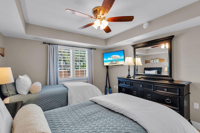 bedroom featuring ceiling fan and a raised ceiling