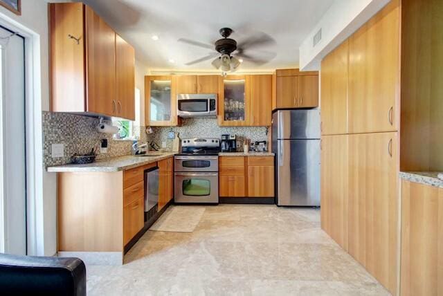 kitchen featuring tasteful backsplash, visible vents, glass insert cabinets, and stainless steel appliances