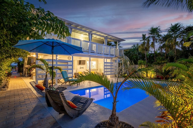 outdoor pool with stairs and a patio