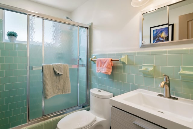 full bath featuring toilet, a wainscoted wall, vanity, tile walls, and an enclosed shower