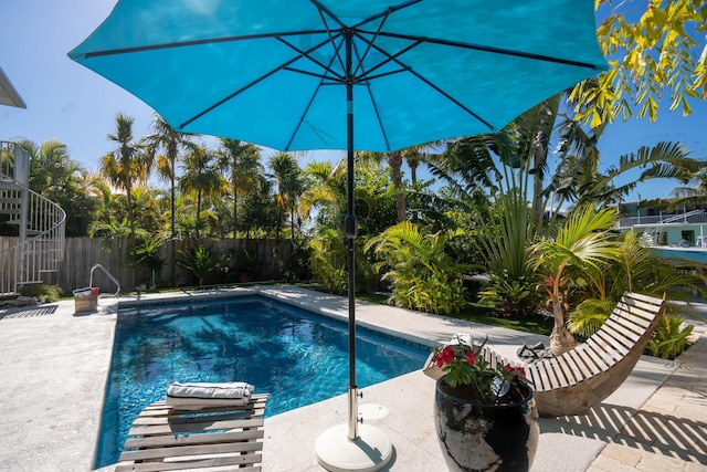 view of swimming pool featuring a patio area, a fenced backyard, and a fenced in pool