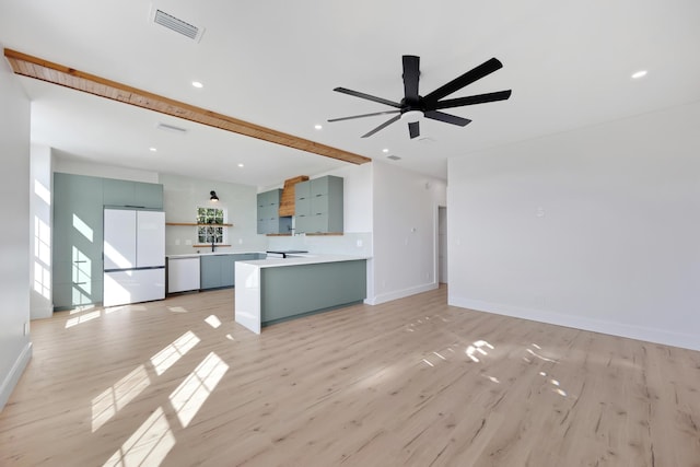 kitchen featuring a peninsula, visible vents, light countertops, light wood-type flooring, and freestanding refrigerator