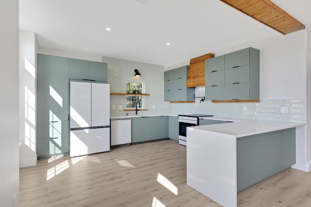 kitchen featuring white appliances, a peninsula, light countertops, open shelves, and backsplash