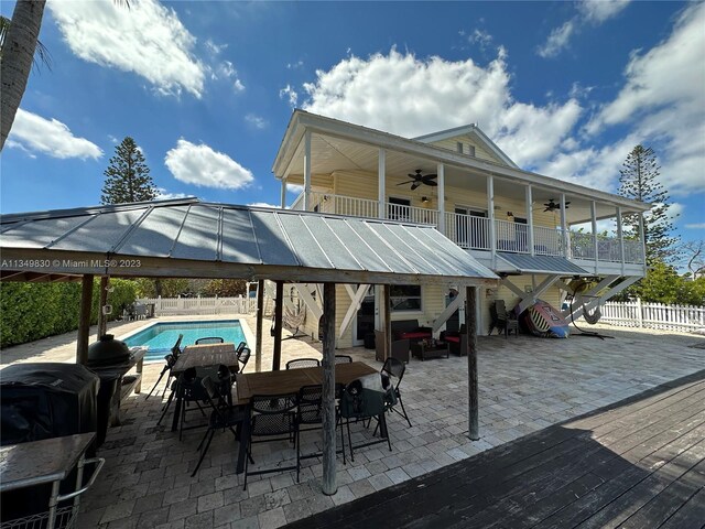 wooden terrace with a water view and ceiling fan