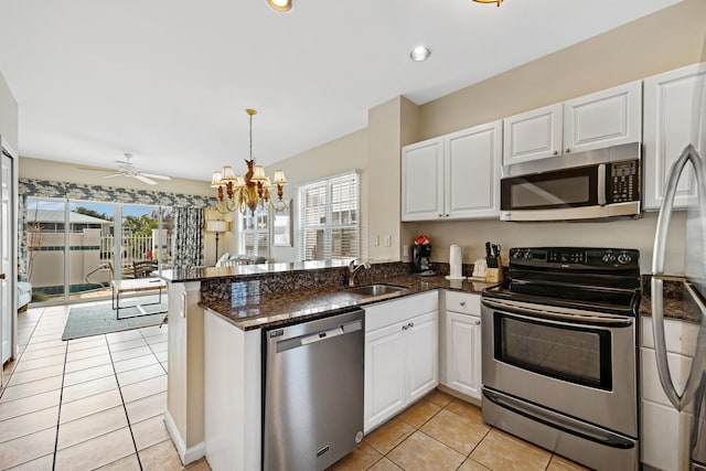 kitchen featuring white cabinets, a peninsula, stainless steel appliances, and a sink