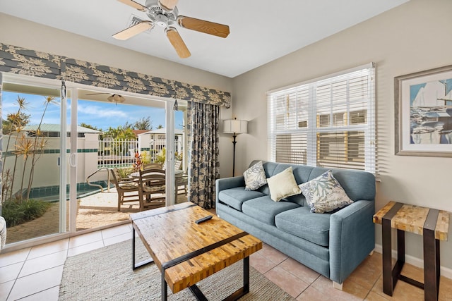 living room with light tile patterned floors, baseboards, and ceiling fan