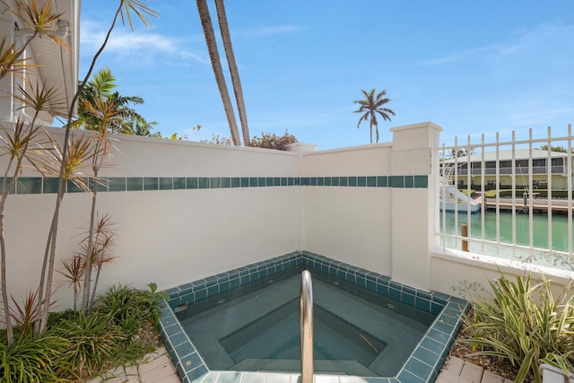 view of pool with an in ground hot tub and a water view