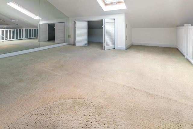 bonus room featuring vaulted ceiling with skylight and carpet