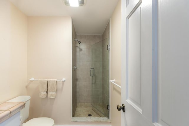 bathroom featuring toilet, vanity, and a shower with shower door