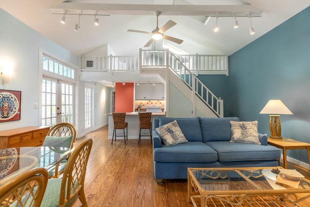 living room featuring french doors, rail lighting, high vaulted ceiling, ceiling fan, and hardwood / wood-style floors