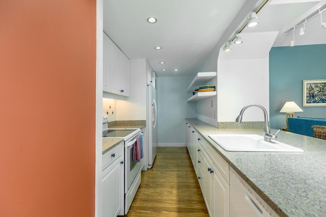 kitchen with sink, wood-type flooring, track lighting, white appliances, and white cabinets