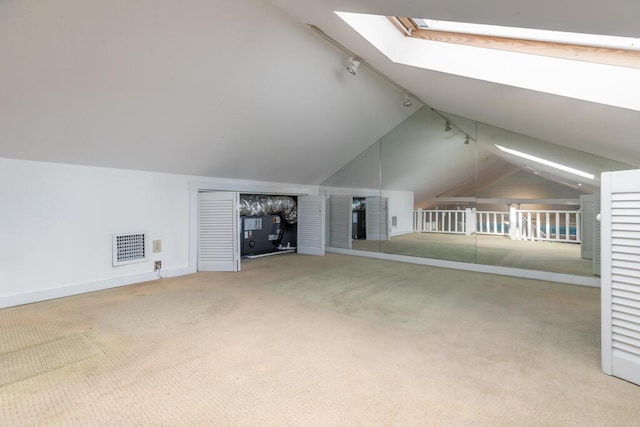 bonus room with light colored carpet and lofted ceiling with skylight