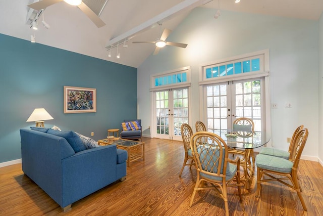 living room with rail lighting, high vaulted ceiling, light wood-type flooring, and french doors