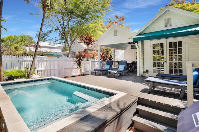 view of swimming pool with french doors, ceiling fan, and a deck