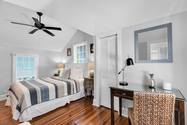 bedroom with vaulted ceiling, dark hardwood / wood-style floors, ceiling fan, and a closet