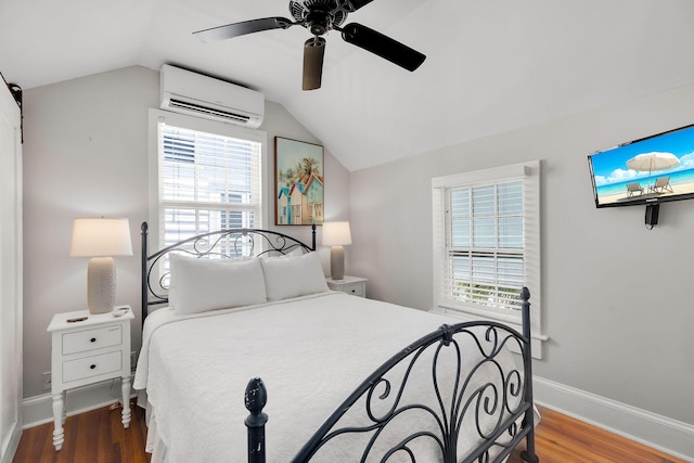 bedroom featuring multiple windows, hardwood / wood-style floors, lofted ceiling, and a wall mounted AC