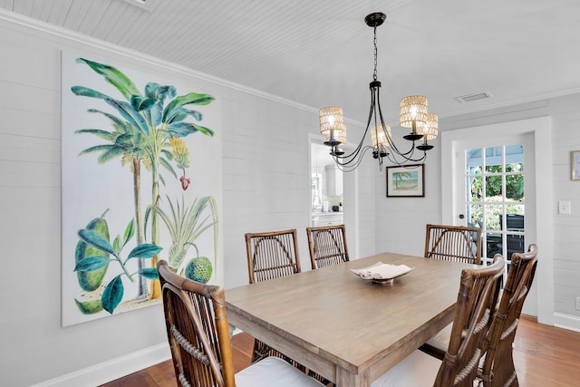 dining area with crown molding, dark wood-type flooring, and a notable chandelier