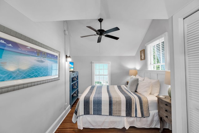 bedroom with multiple windows, vaulted ceiling, dark wood-type flooring, and ceiling fan