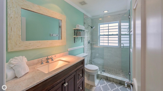 bathroom featuring vanity, ornamental molding, toilet, and a tile shower