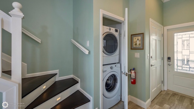 clothes washing area with stacked washer and clothes dryer and light hardwood / wood-style flooring