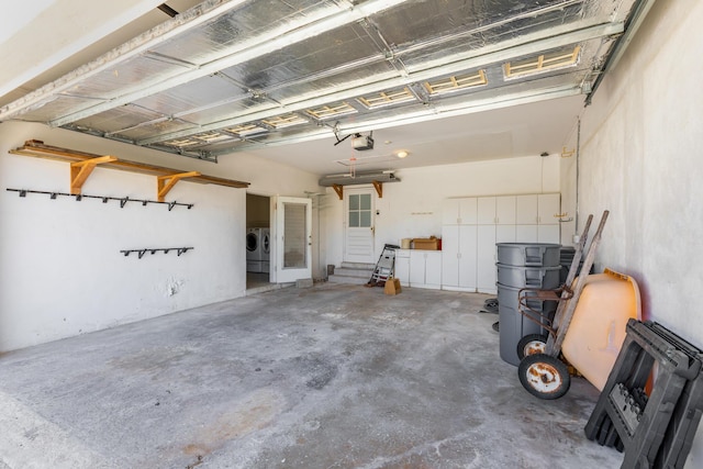 garage with a garage door opener and separate washer and dryer