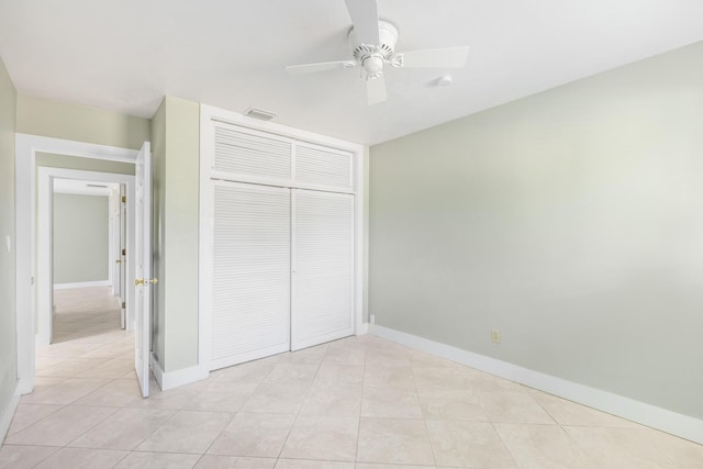 unfurnished bedroom with ceiling fan, a closet, and light tile patterned floors