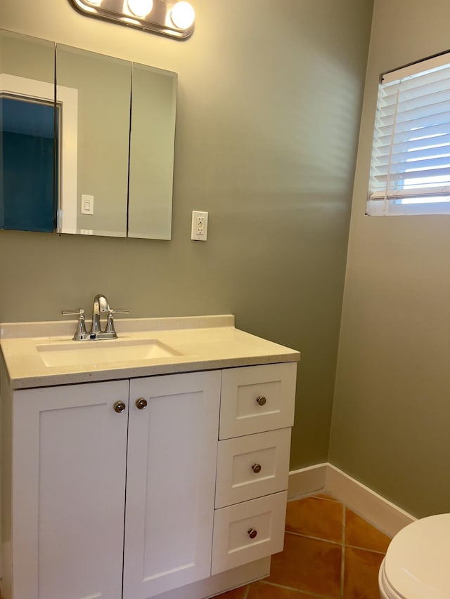 bathroom with tile patterned flooring, vanity, and toilet