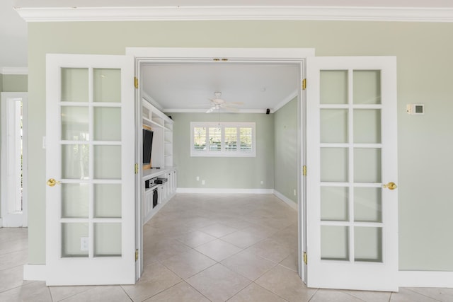 unfurnished living room with ceiling fan, ornamental molding, and light tile patterned floors