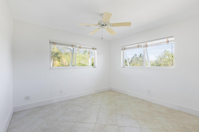 tiled empty room featuring ceiling fan