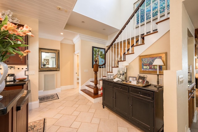 foyer with ornamental molding and a high ceiling