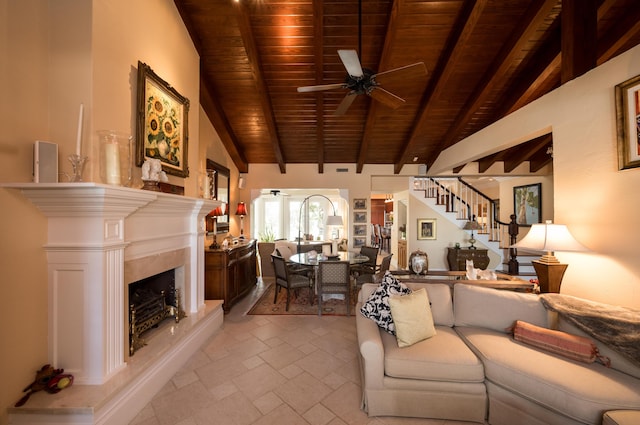 living room featuring lofted ceiling with beams, wooden ceiling, a fireplace, and ceiling fan