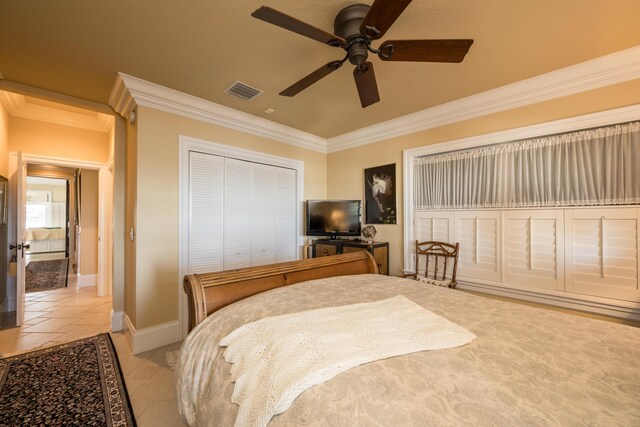 tiled bedroom with ornamental molding, ceiling fan, and a closet