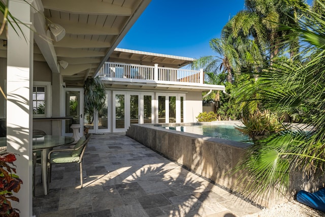 view of patio featuring a balcony and french doors