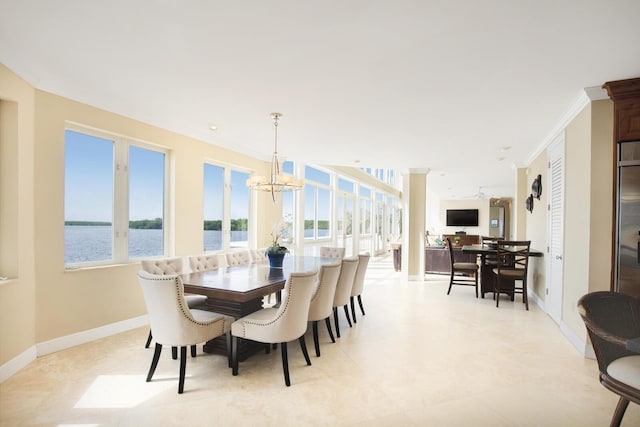 dining room with a water view, ornamental molding, a healthy amount of sunlight, and a chandelier