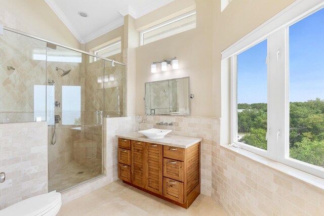 bathroom with tile walls, an enclosed shower, vanity, ornamental molding, and toilet