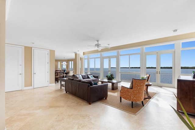 living room featuring french doors, ceiling fan, and a water view