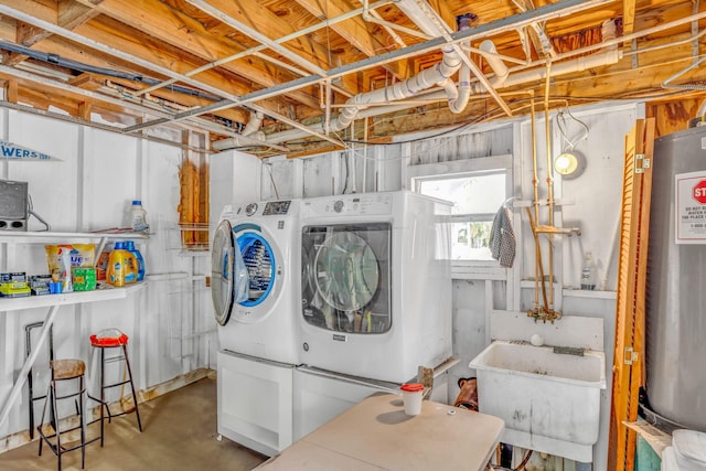 washroom with water heater, washer and dryer, and sink