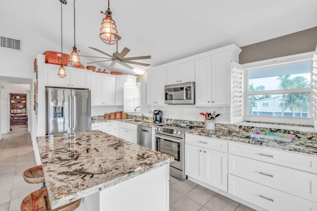 kitchen with pendant lighting, sink, a breakfast bar, stainless steel appliances, and a center island