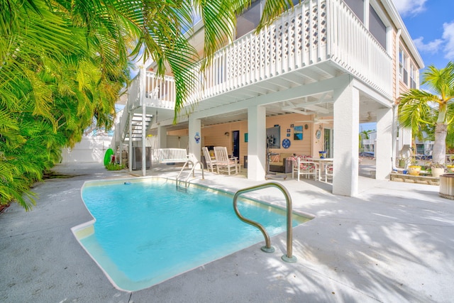 view of swimming pool featuring ceiling fan and a patio