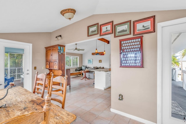 tiled dining area featuring lofted ceiling and ceiling fan