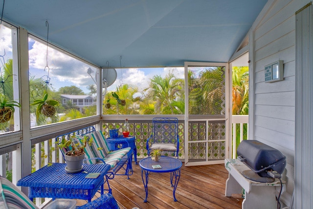 sunroom featuring vaulted ceiling and a healthy amount of sunlight