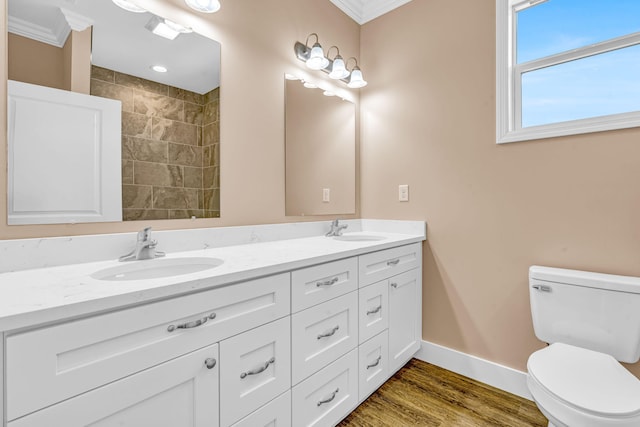 full bath featuring double vanity, a sink, toilet, and baseboards