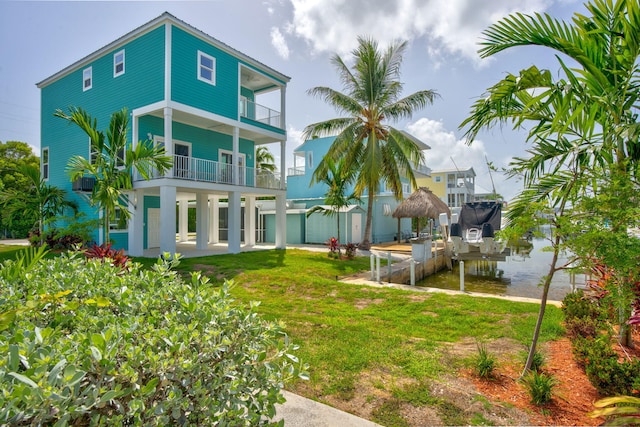 exterior space featuring a lawn, boat lift, and a balcony