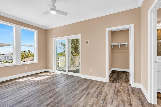 unfurnished bedroom featuring access to outside, crown molding, and wood finished floors